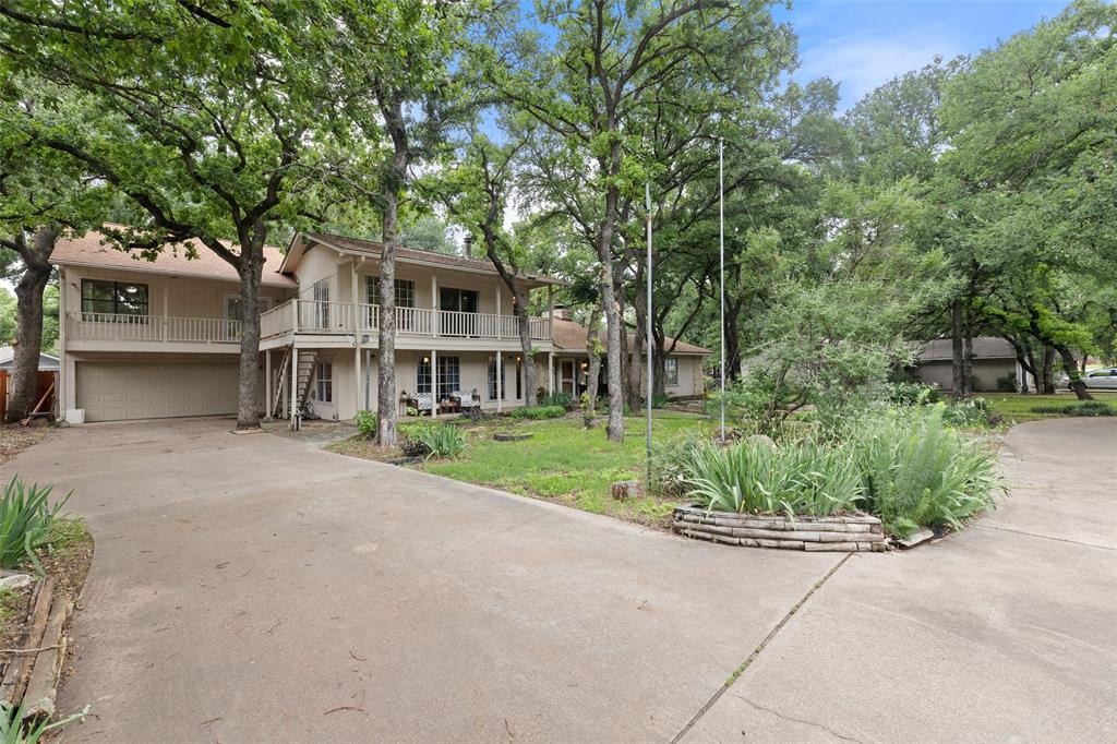 a front view of a house with a yard and potted plants