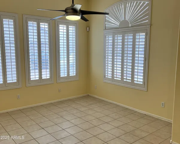 an empty room with windows and chandelier