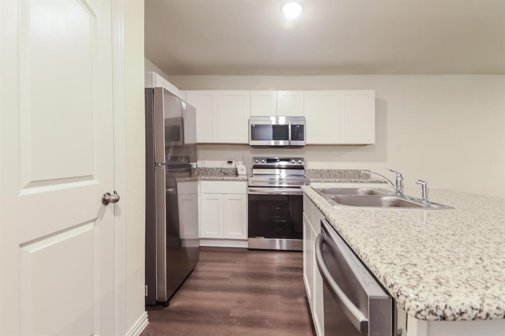 510 East Shepherd Street Denison, TX 75021 - Photo 11 of 21 a kitchen with a stove a sink and a refrigerator