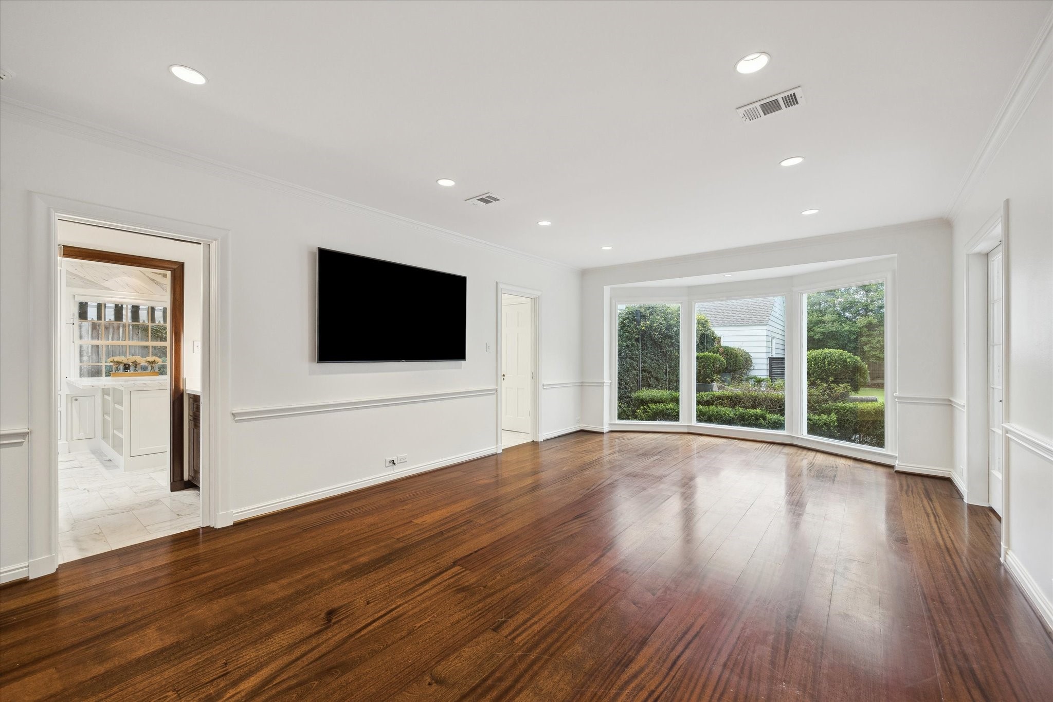 2440 Inwood Drive Houston, TX 77019 - Photo 11 of 25 a view of an empty room with wooden floor and windows