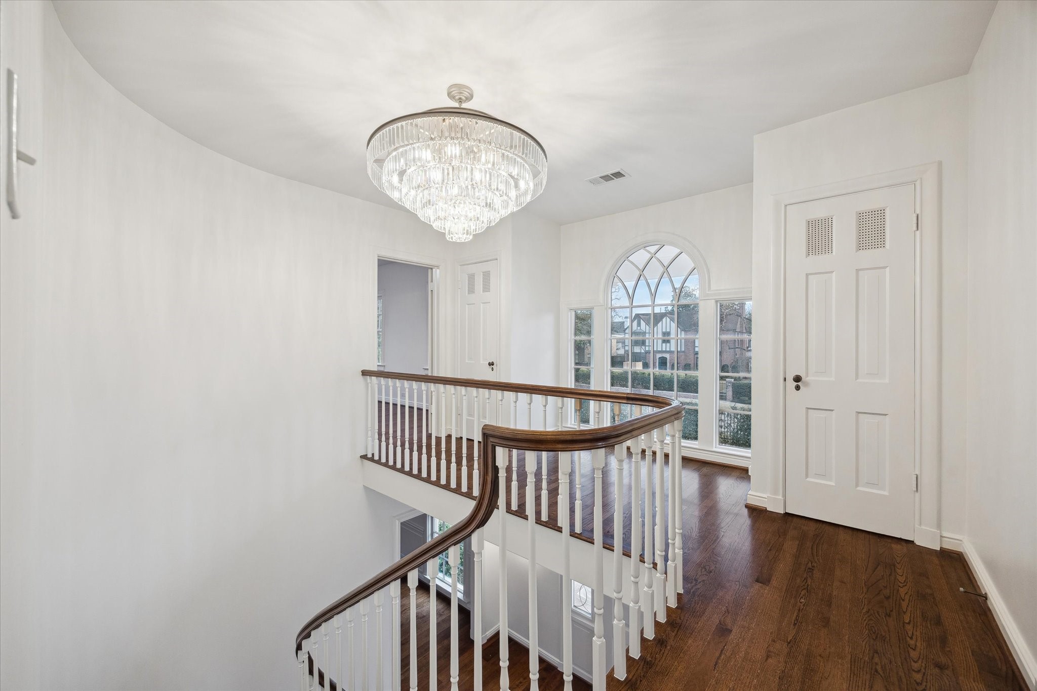 2440 Inwood Drive Houston, TX 77019 - Photo 13 of 25 an empty room with wooden floor windows and a chandelier
