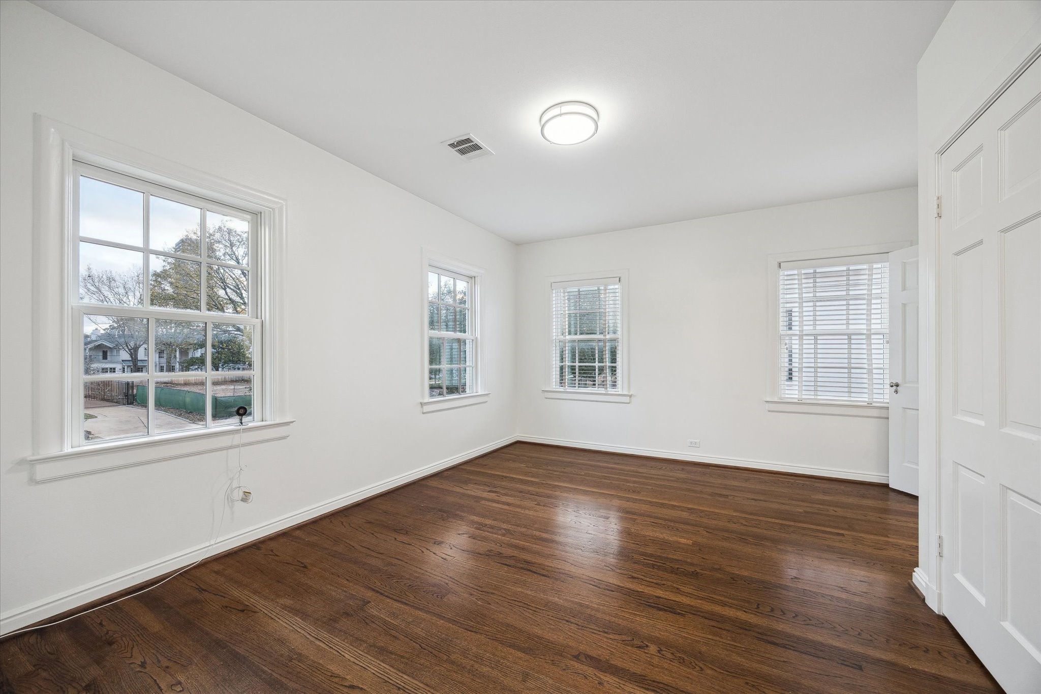 2440 Inwood Drive Houston, TX 77019 - Photo 19 of 25 a view of an empty room with wooden floor and a window