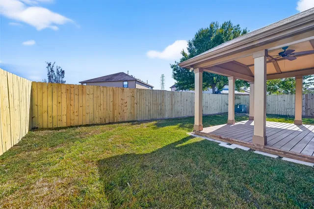 a view of a house with a yard plants and large tree
