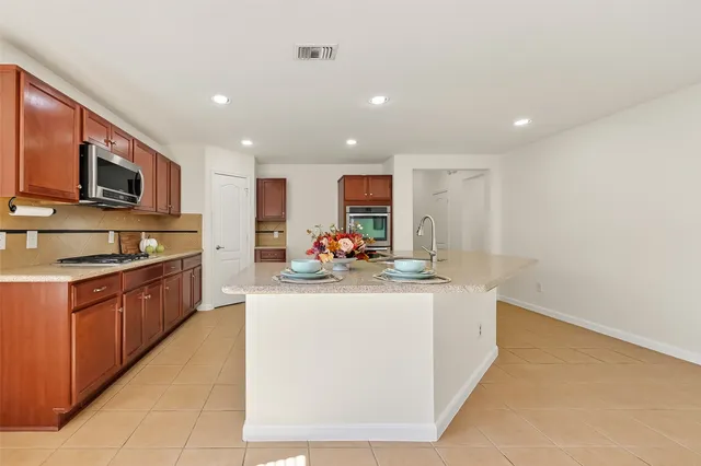 a kitchen with stainless steel appliances granite countertop a sink stove and cabinets