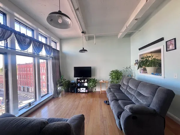 a living room with furniture a flat screen tv and a large window