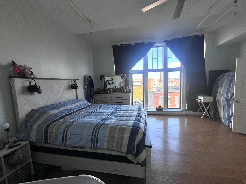 16 Merrimack Street, Unit 4A Lowell, MA 01852 - Photo 11 of 24 a bedroom with a bed and a large window