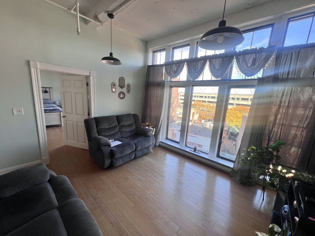16 Merrimack Street, Unit 4A Lowell, MA 01852 - Photo 2 of 24 a living room with furniture and wooden floor