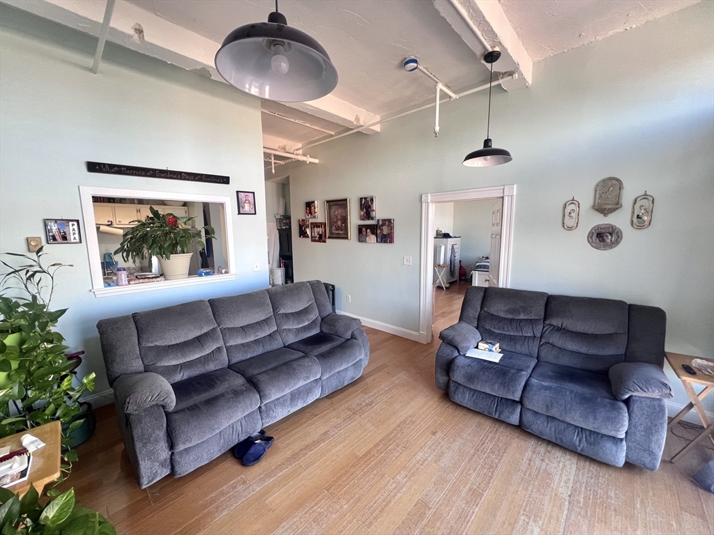16 Merrimack Street, Unit 4A Lowell, MA 01852 - Photo 3 of 24 a living room with furniture and a wooden floor