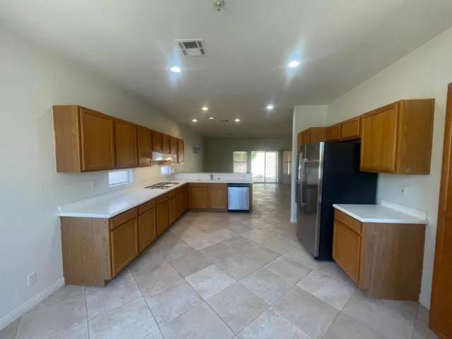 a kitchen with stainless steel appliances a refrigerator and a stove top oven