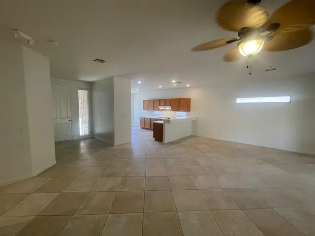 a view of empty room with a kitchen
