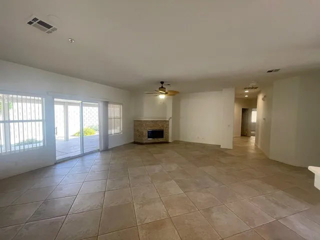a view of an empty room with a fireplace and a window