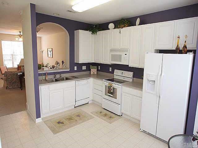 8262 City Loft Court Raleigh, NC 27613 - Photo 4 of 8 a kitchen with white cabinets and white appliances