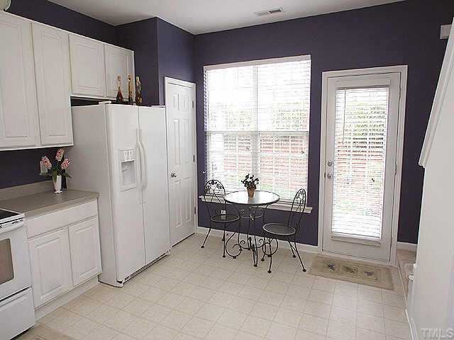 8262 City Loft Court Raleigh, NC 27613 - Photo 5 of 8 a kitchen with a refrigerator a sink and white cabinets