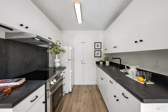 a kitchen with granite countertop a sink stove and cabinets