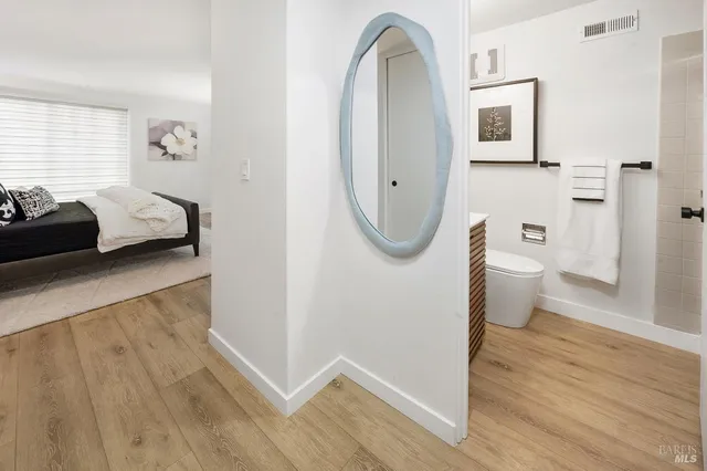 a bathroom with a toilet mirror and vanity