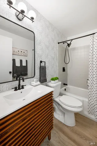 a bathroom with a sink toilet mirror and shower