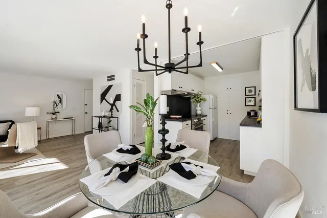 a living room with furniture a flat screen tv and kitchen view