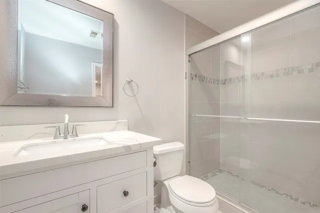 a bathroom with a sink a toilet and shower