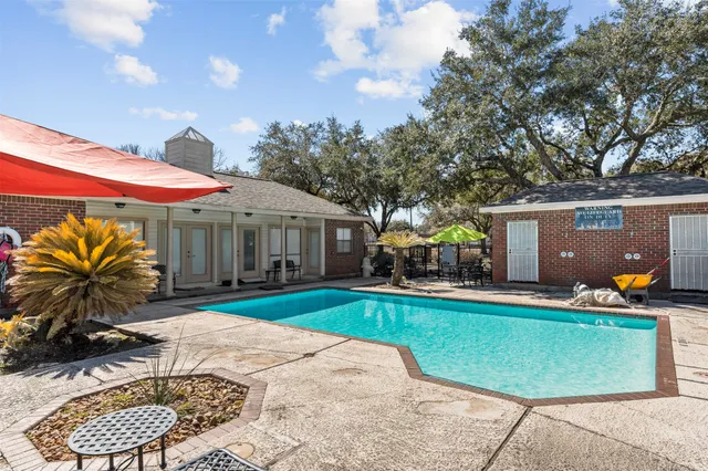 a view of a house with backyard swimming pool and sitting area