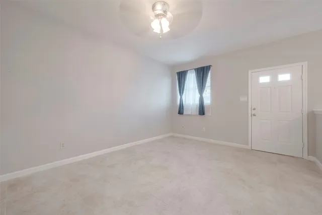 an empty room with stairs and windows