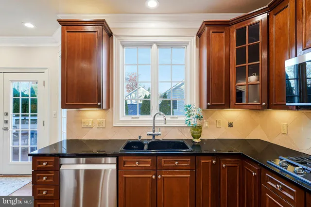 a kitchen with granite countertop a refrigerator stove microwave and cabinets
