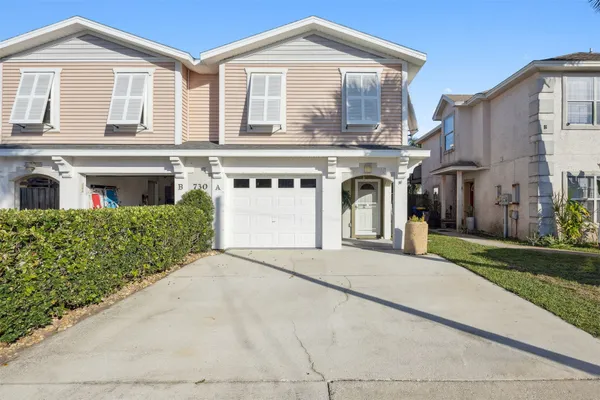 a front view of a house with a garden and garage