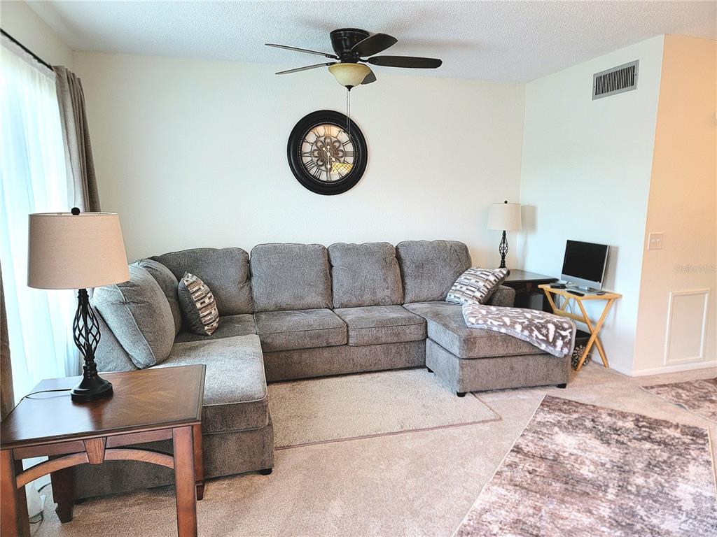 2371 Israeli Drive, Unit 39 Clearwater, FL 33763 - Photo 3 of 34 a living room with furniture a rug and a wall painting