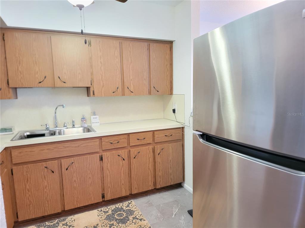2371 Israeli Drive, Unit 39 Clearwater, FL 33763 - Photo 8 of 34 a kitchen with granite countertop white cabinets white refrigerator and sink