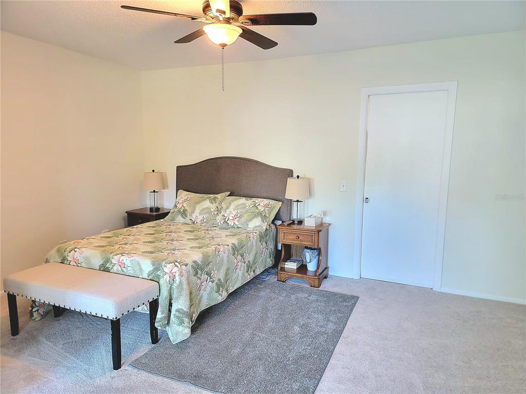 2371 Israeli Drive, Unit 39 Clearwater, FL 33763 - Photo 9 of 34 a bedroom with a bed and a chandelier
