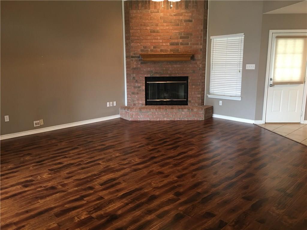 2218 Old Ironsides Road Abilene, TX 79601 - Photo 5 of 26 an empty room with wooden floor fireplace and windows