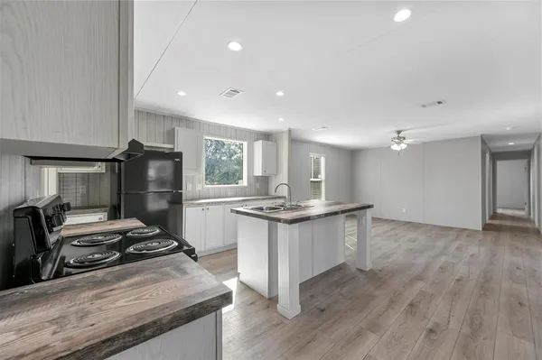 a kitchen with sink stove and refrigerator
