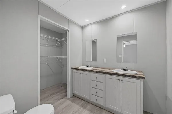 a bathroom with a double vanity sink mirror and toilet