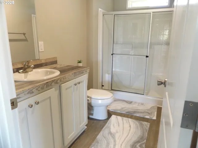 a bathroom with a granite countertop sink toilet and shower