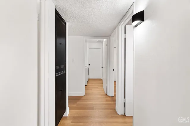 a view of a hallway with wooden floor and closet
