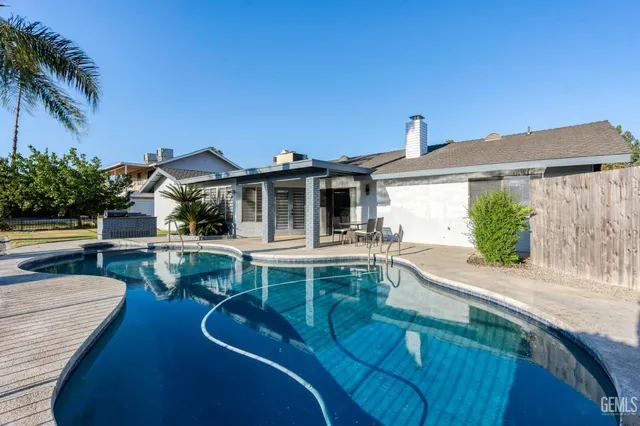 a view of house with swimming pool outdoor seating and city view