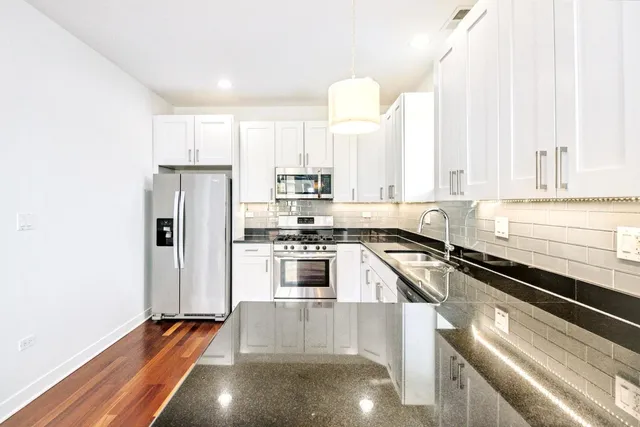 a kitchen with stainless steel appliances a refrigerator sink and cabinets