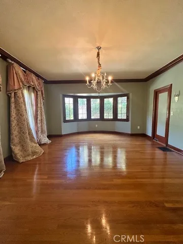 a view of a living room with hardwood floor and chandelier