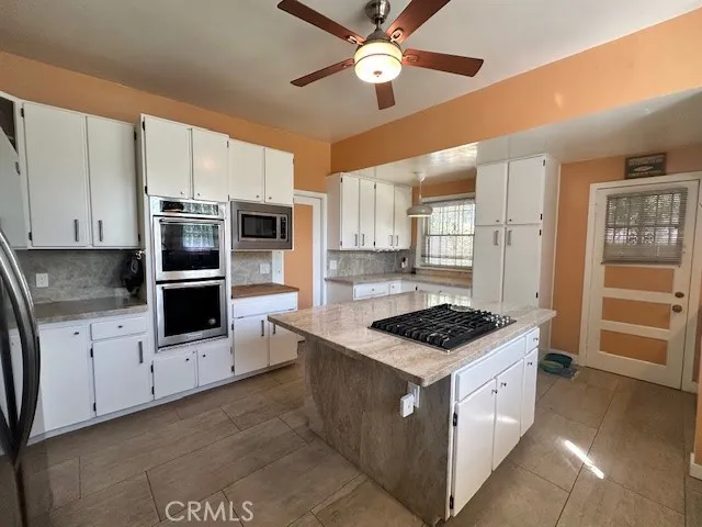 a kitchen with stainless steel appliances kitchen island granite countertop a stove and a refrigerator