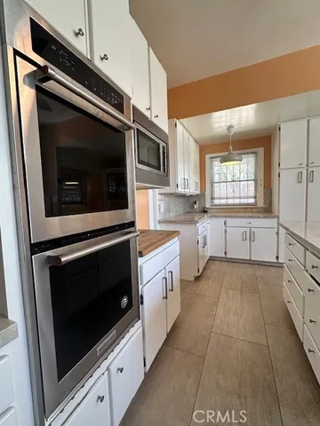 a kitchen with stainless steel appliances a stove microwave and sink