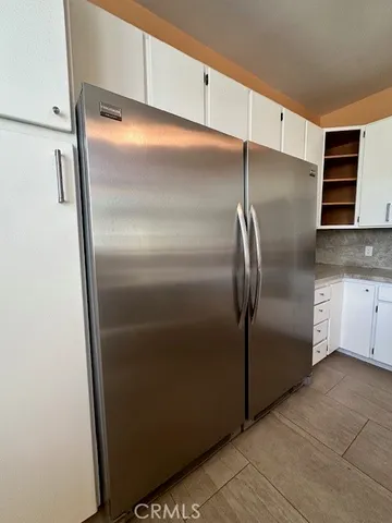 a metallic refrigerator freezer sitting in a kitchen