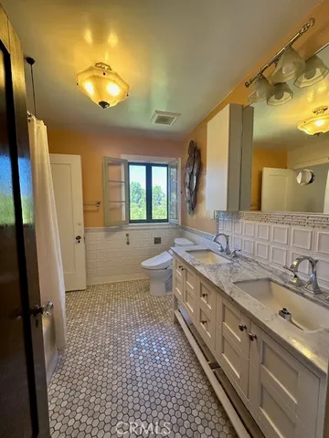 a bathroom with a double vanity sink mirror and toilet