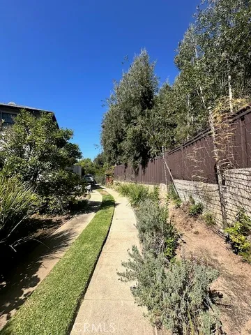 a view of a yard with plants and a bench