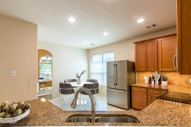 a kitchen with a refrigerator and a stove top oven