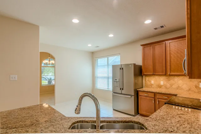 a kitchen with stainless steel appliances granite countertop a refrigerator and a sink