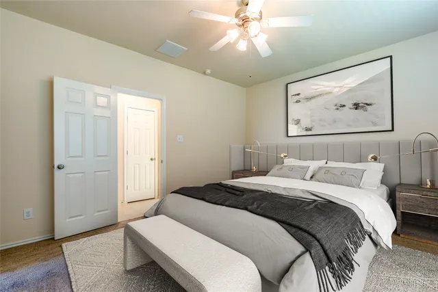 a bedroom with a large bed and a chandelier