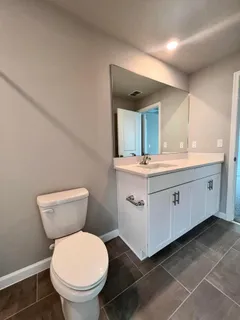 a bathroom with a toilet sink and mirror