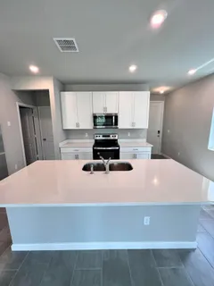 a kitchen with kitchen island sink stove and refrigerator