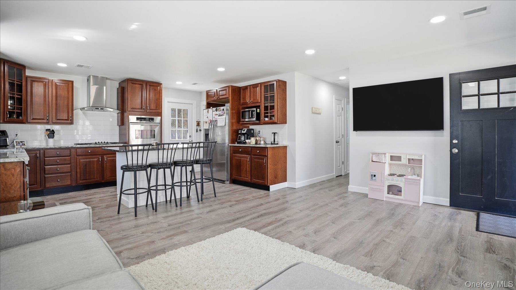 130 Beaver Dam Road Brookhaven, NY 11719 - Photo 13 of 30 Kitchen with glass fronted cabinets, a breakfast bar area, a center island, stainless steel appliances, and recessed lighting