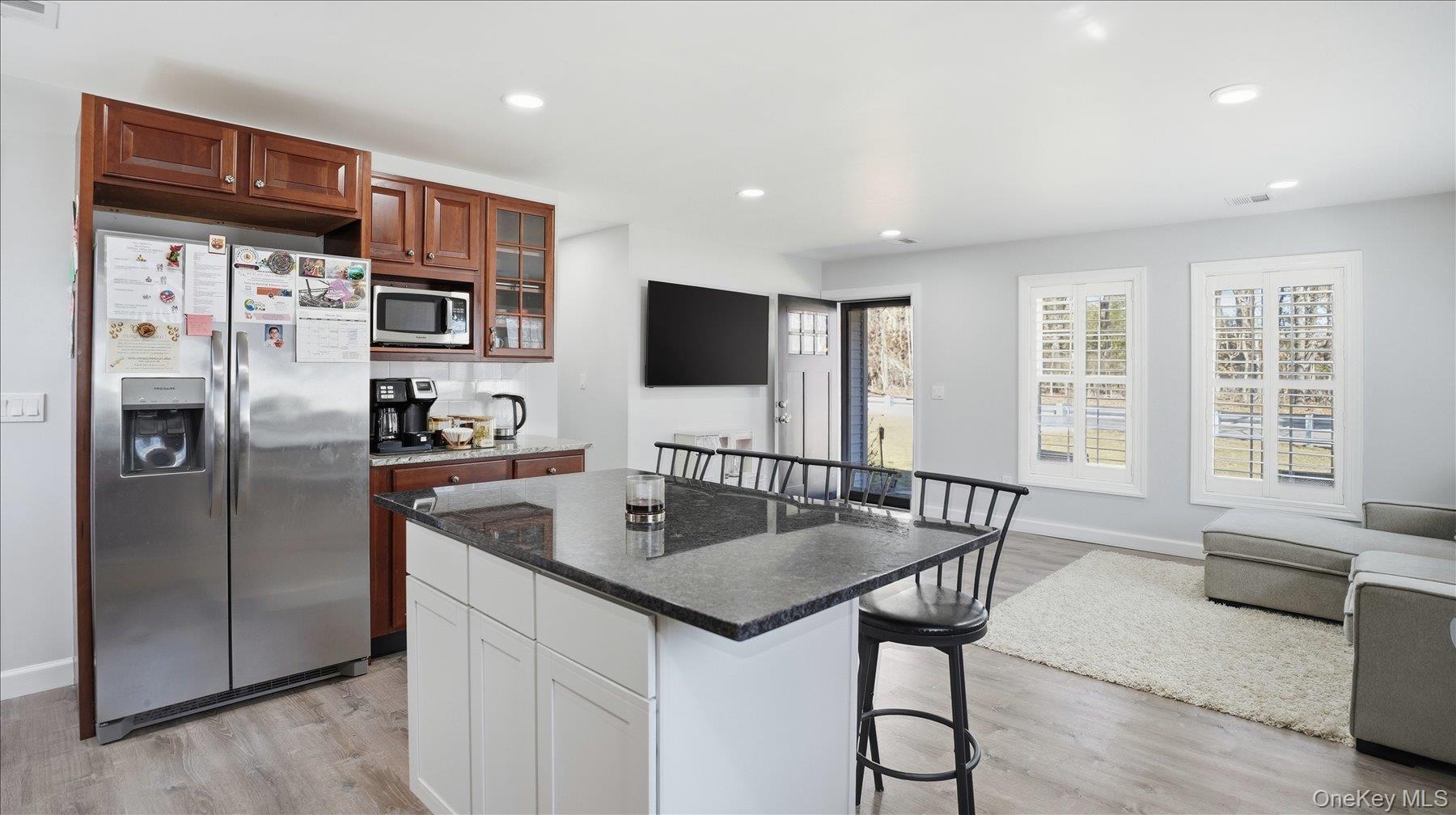 130 Beaver Dam Road Brookhaven, NY 11719 - Photo 17 of 30 Kitchen featuring a kitchen breakfast bar, stainless steel appliances, light wood finished floors, recessed lighting, and glass fronted cabinets