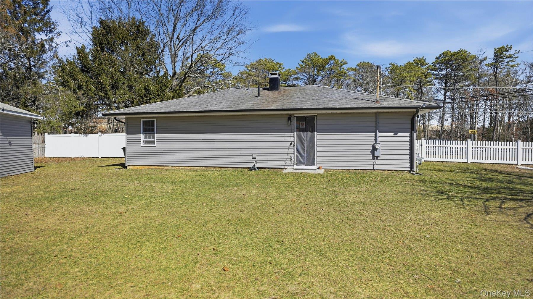 130 Beaver Dam Road Brookhaven, NY 11719 - Photo 27 of 30 Rear view of property featuring a chimney and roof with shingles